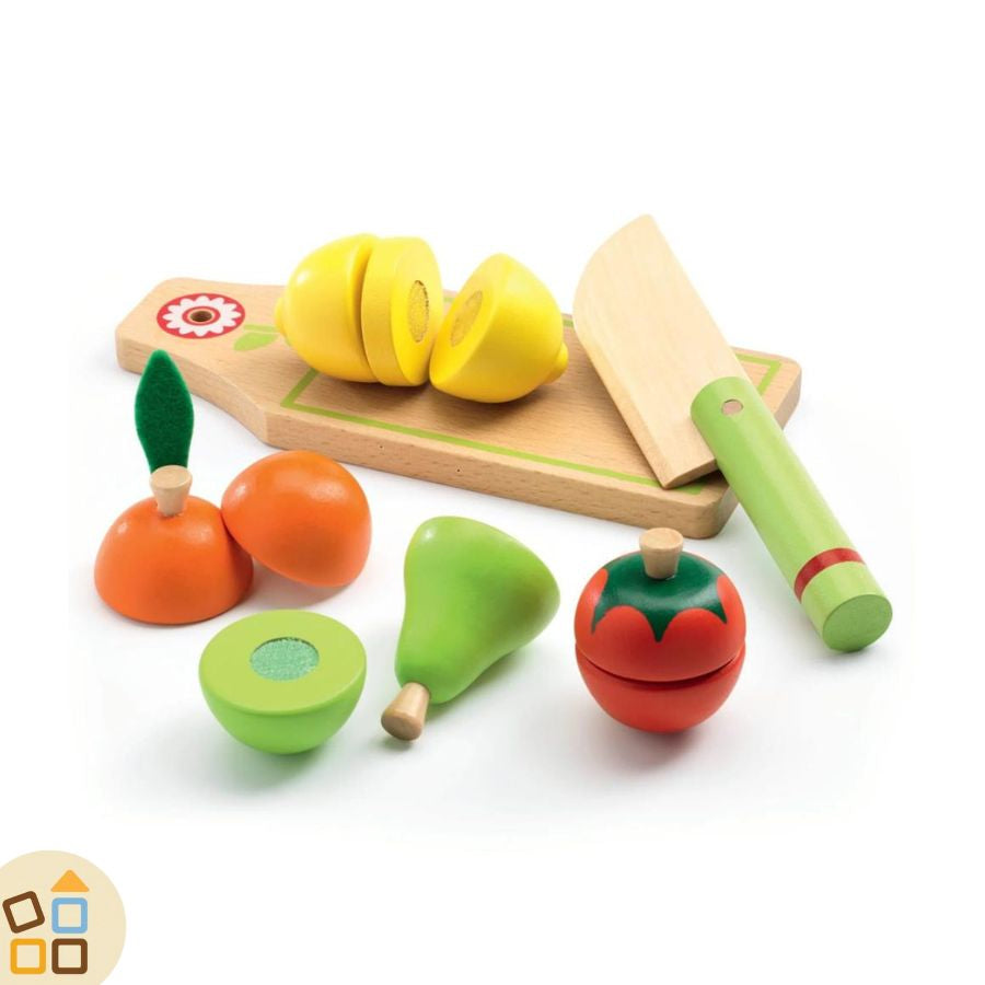 Frutta in legno e velcro giocattolo da tagliare: limone tagliato in 3 pezzi sul tagliere con a fianco il coltello giocattolo in legno. Davanti 1 arancia, 1 pera e 1 pomodoro tagliati a metà