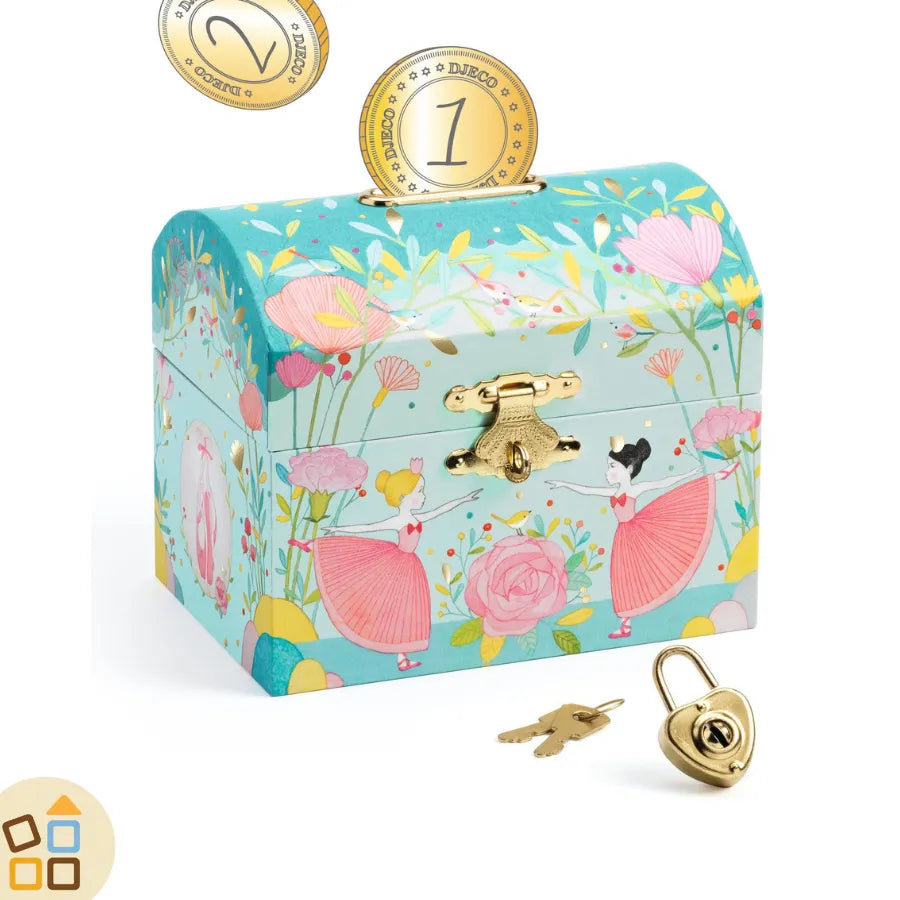 Salvadanaio decorativo con motivi floreali in vari toni dell'azzurro, fiori rosa e gialli e due ballerine classiche con vestiti rosa. Dalla base in velluto, realizzato in legno FSC. Ha chiusura in metallo dorato con lucchetto in metallo dorato a forma di cuore e 2 chiavi